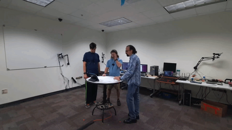 three people working collaboratively around a round table